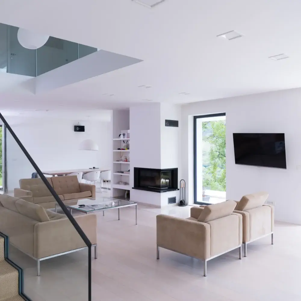 Modern open-plan living room with large windows and neutral furniture